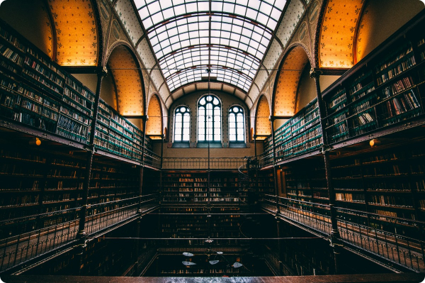 Grand library with arched ceilings, large bookshelves, and a glass roof